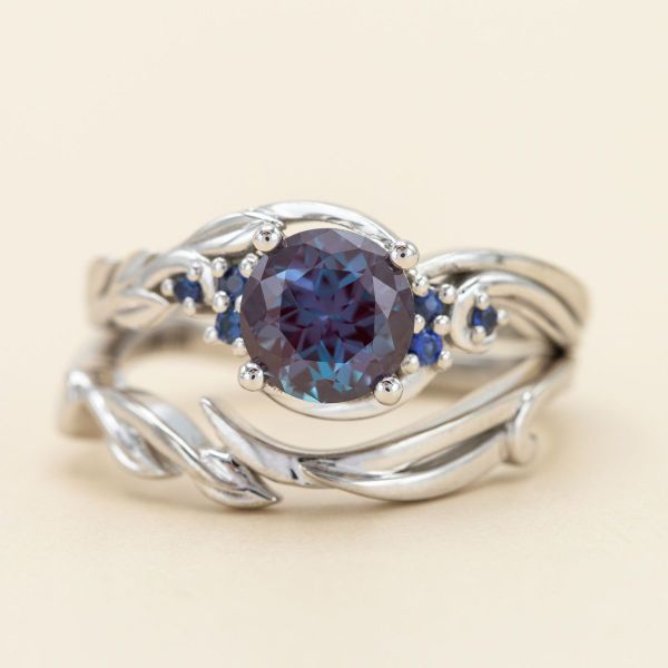 A round brilliant alexandrite is accented by blue sapphires in this engagement ring.