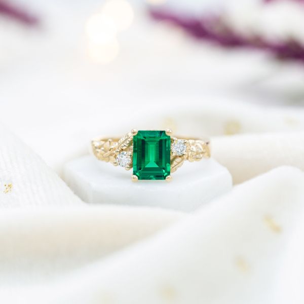 This emerald engagement ring features a lab emerald.