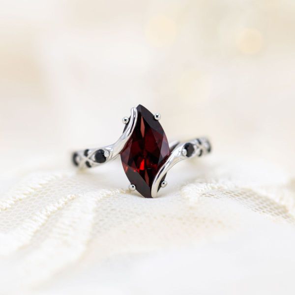 This black magic engagement ring features a crimson marquise cut garnet Mozambique on a white gold band.