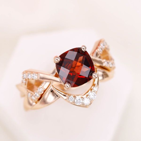 A cushion cut Mozambique garnet sits at the center of this non-traditional bridal set.