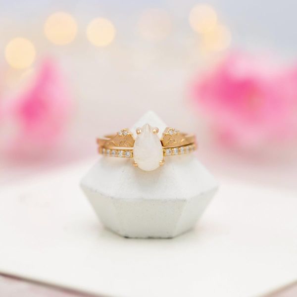 This rose gold set features mountains on the wedding band hugging the moonstone center.