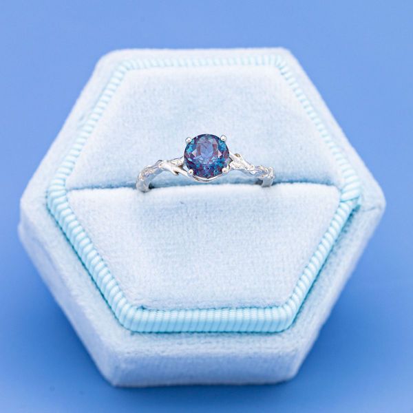 A round alexandrite blossoms at the center of this tree inspired engagement ring.