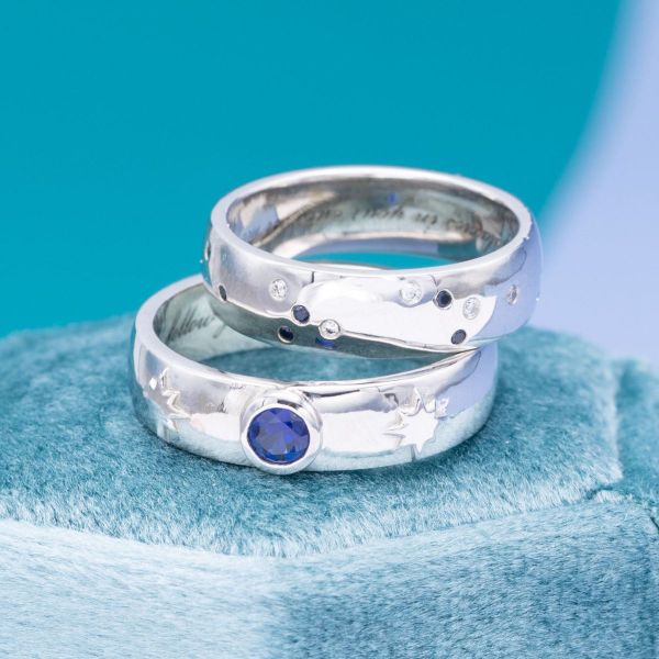 Platinum starburst details flanking a blue sapphire in Emery’s engagement ring echo the constellation of blue sapphires and diamonds in their partner’s.