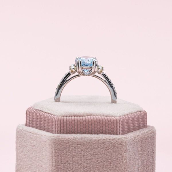 This engagement ring’s white gold double-prongs cradle an oval cut aquamarine as petite pearls decorate either side.
