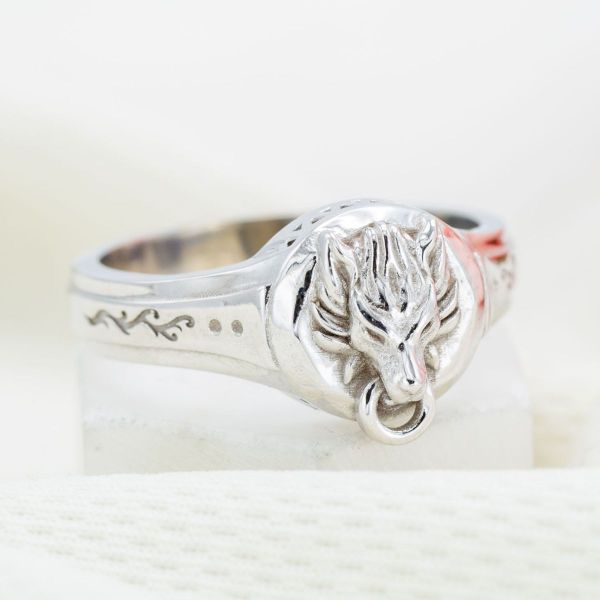 A lone wolf in white gold guards the heart of this gentleman’s engagement ring.