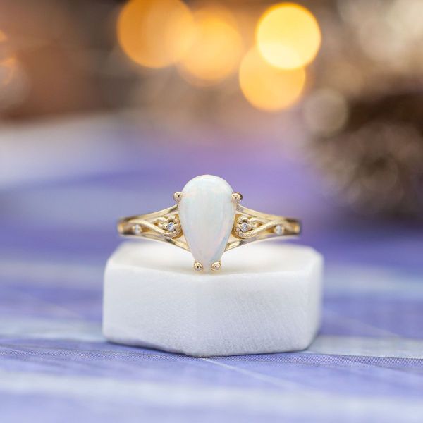 White opal and yellow gold come together perfectly in this pear cut center stone engagement ring.