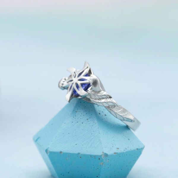 A blue tanzanite center stone is supported by cute kitty paws in this Nenya inspired ring.