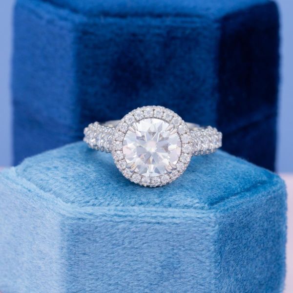 Moissanite accents add bling to the round moissanite ring.