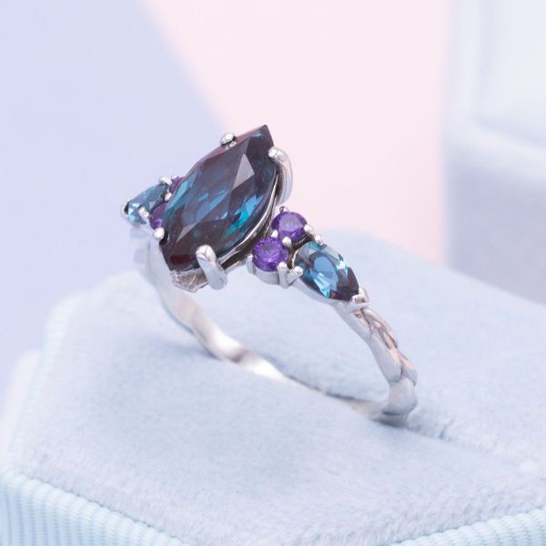 A love of astronomy inspired this alexandrite and purple sapphire engagement ring with a marquise cut center stone.