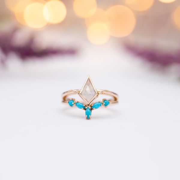 Using colored gem accents can be a great way to save on budget while adding a fun pop of color. This set of turquoise stones flanking the kite-cut moonstone center added less than $200 to the price of the ring set, which would have been closer to $450 for mined diamonds.