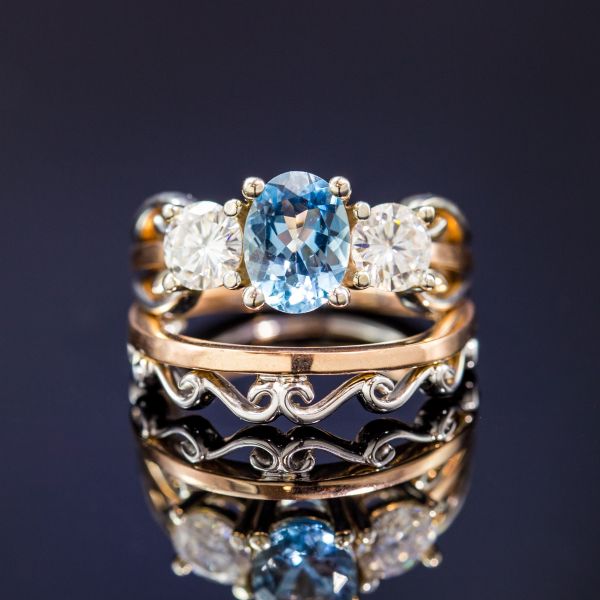 经典的3石订婚戒指与海蓝宝石和钻石在混合的金属设计中，与海浪的白色金色曲线。