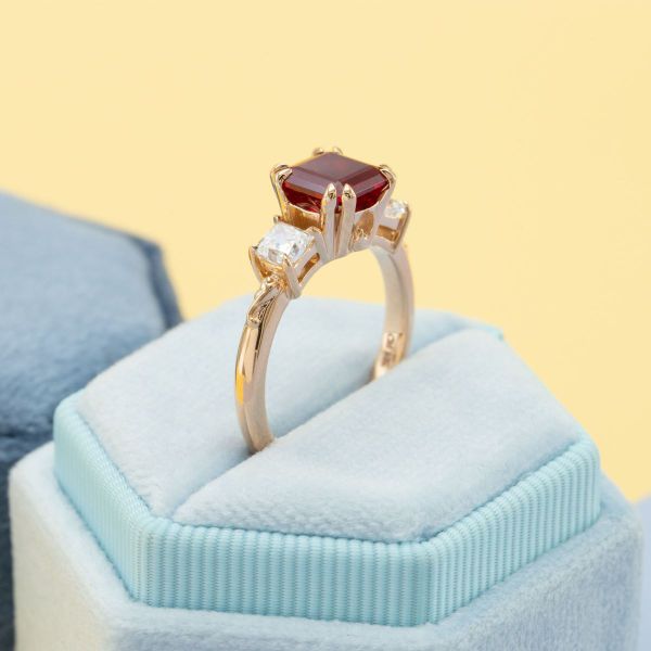 Enclosed in luxe rose gold double-prongs, a lab ruby smolders next to two princess cut diamonds on a petite band.