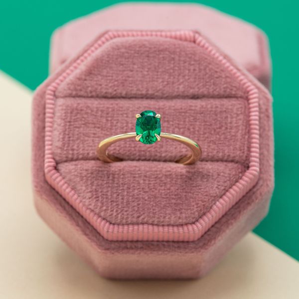 The emerald at the center of this yellow gold solitaire engagement ring is 1 carat.