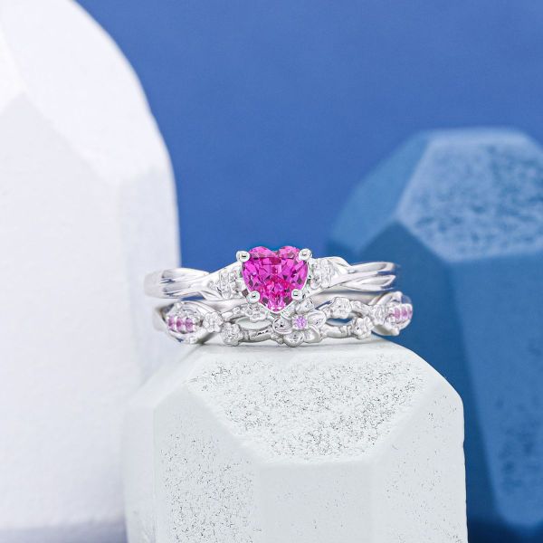 A heart shaped pink sapphire is the center of this white gold bridal set.