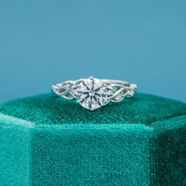 How well are you guessing? The diamond at the center of this engagement ring is a lab created stone.