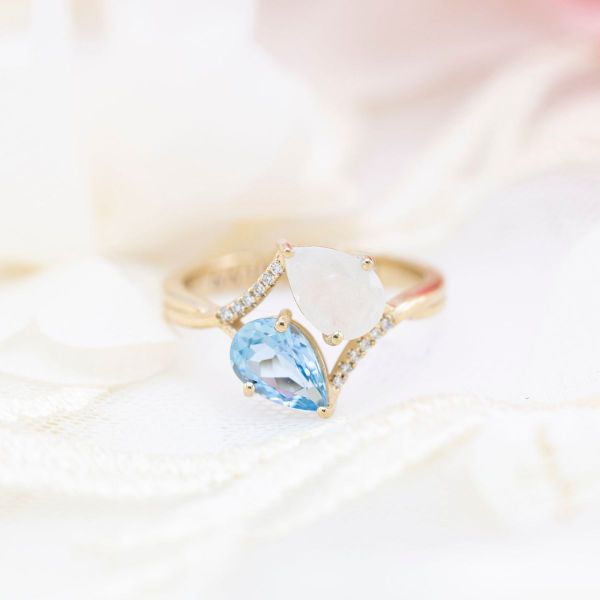 The opal in this toi et moi setting brings out the light blue of the aquamarine.