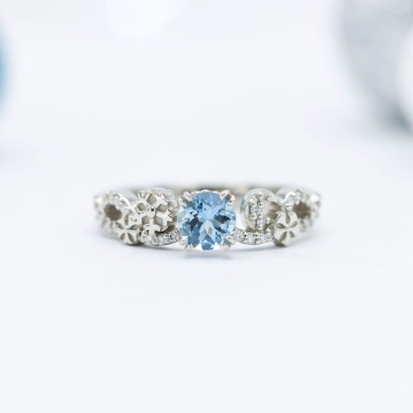 Snowflakes and an icy moon take center stage in this winter inspired aquamarine and diamond engagement ring.