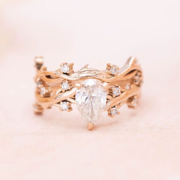 This autumn-inspired rose gold bridal set has a branch-like design with a lab diamond center stone and accents.