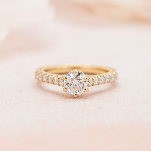 Moissanite accents line the arches holding the moissanite center stone above the couple’s initials in this cathedral set engagement ring.