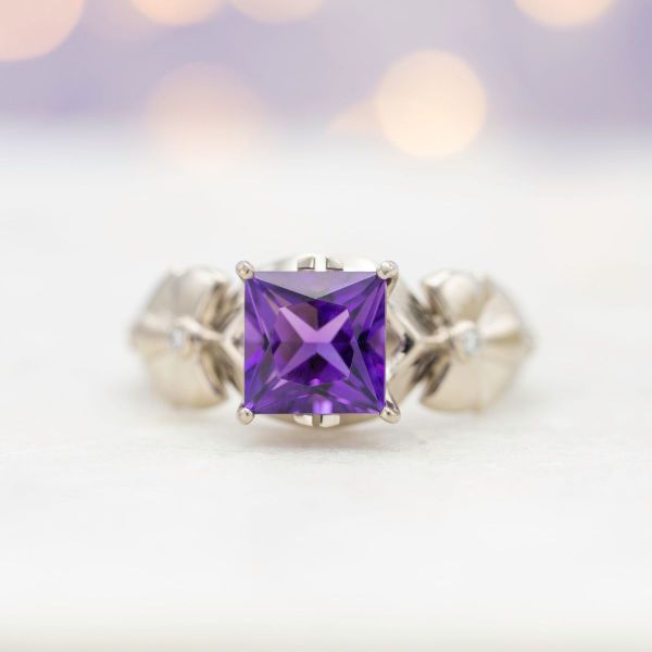 A princess cut amethyst is held by white gold and accented by diamonds.