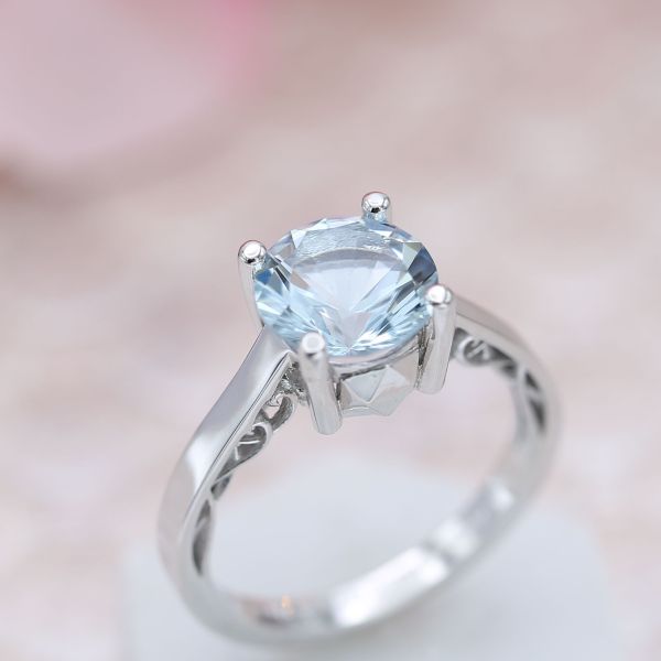 一个时尚的海蓝宝石订婚戒指隐藏着典雅的海洋启发了乐队内部的金属丝的波浪。