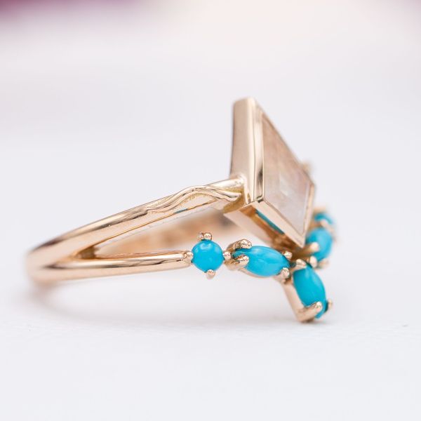 Turquoise accents the moonstone centerpiece on this rose gold ring.