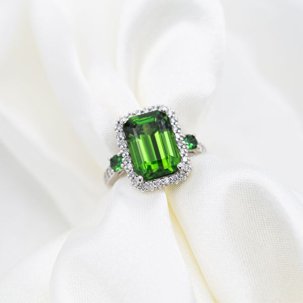 A chrome tourmaline is the center stone of this haloed engagement ring.