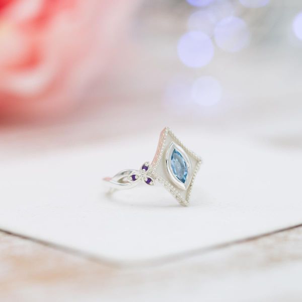 Art Deco-influenced engagement ring featuring aquamarine and amethyst accents.