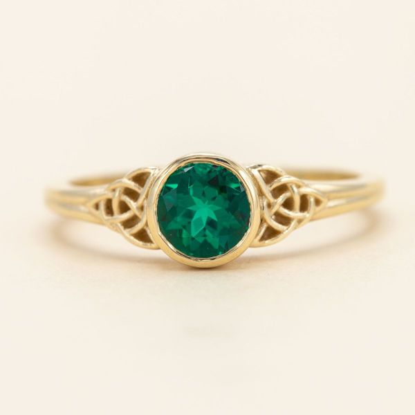 We’re charmed by the Irish green of the emerald center stone in this trinity knot engagement ring.