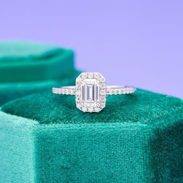 An emerald cut moissanite with a sparkly halo.