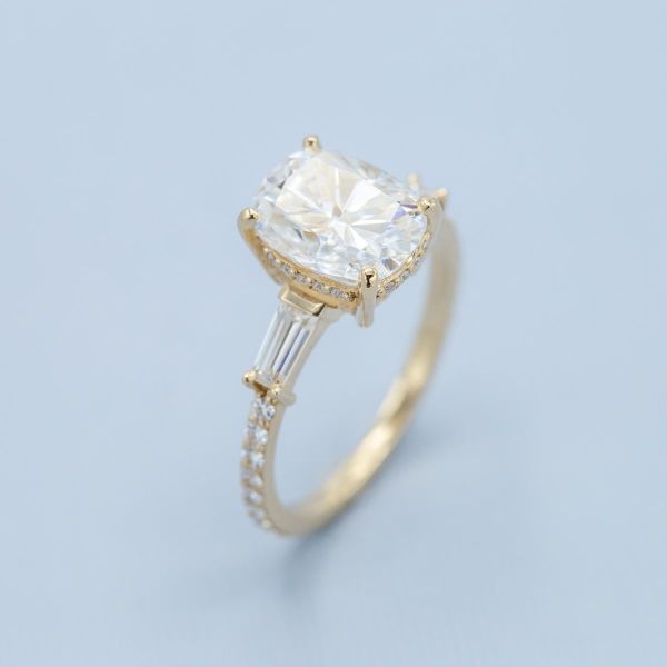 Baguette moissanites act as accents in this yellow gold engagement ring.