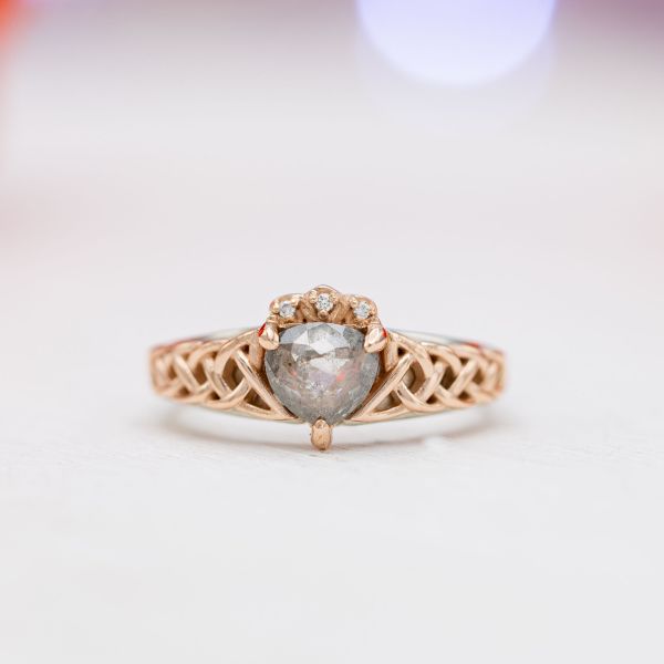 Inspired by a Claddagh ring, this ring features a rose cut salt & pepper diamond at the center of the Celtic rope band.