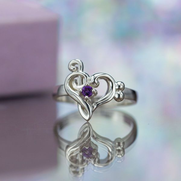 A purple amethyst adds a pop of color to this musical engagement ring.