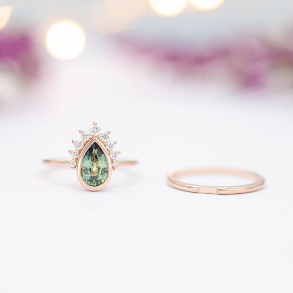 Engagement ring with a gorgeous green sapphire and sunburst-style half halo of diamonds.