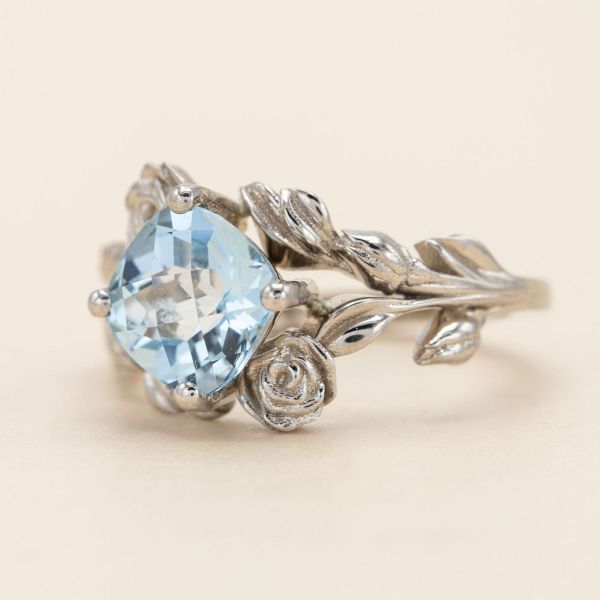 A kite set cushion cut aquamarine comes to life in this floral white gold ring.