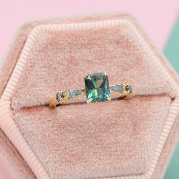 A mysterious ring like this will keep everyone guessing. What is that stone? This teal sapphire pairs perfectly with salt and pepper diamonds to create a mystical feel. We set the stones in yellow gold to add a glowing warmth to the ring.