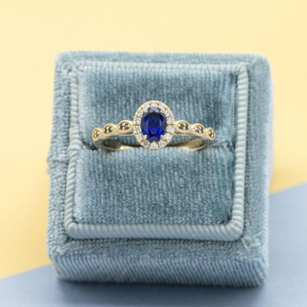 A classic halo turns up the bling factor around this dark blue lab-created sapphire. We achieved the vintage vibe by incorporating scalloped shapes into the yellow gold band and adding milgrain embellishments around the black diamond accents.