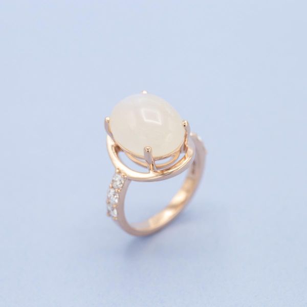 This large moonstone engagement ring's center stone seems to float above an open frame.