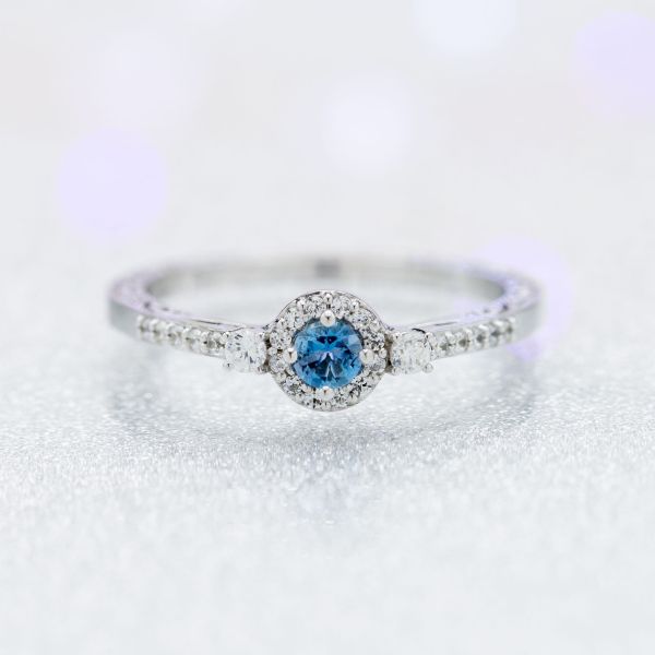 A subtle, delicate take on a classic halo ring, using a smaller center stone to keep the look tastefully minimal.