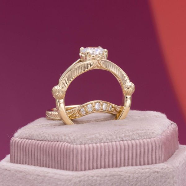 A sparkling round moissanite sits in a beautiful gold setting.