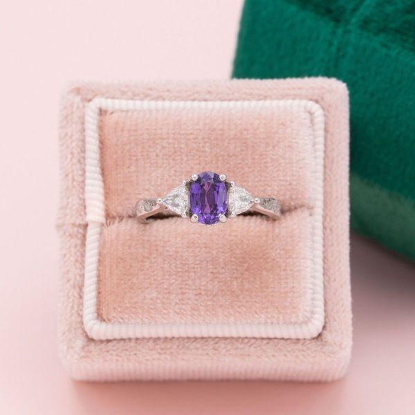 A purple sapphire in white gold with diamond side stones.