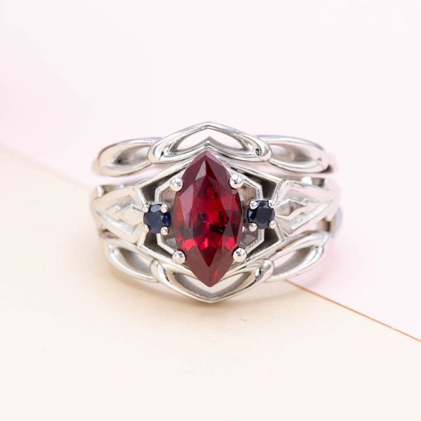 A ruby center stone is flanked by deep blue sapphires in this Spider-man and Venom inspired engagement ring.