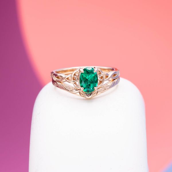 The blue undertones of this pear cut lab emerald are highlighted by a celtic inspired rose gold setting.