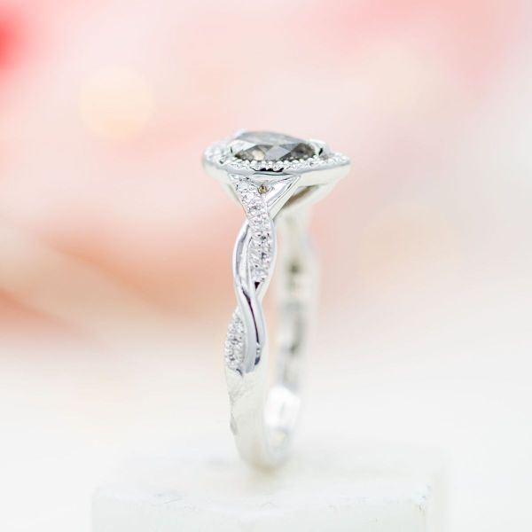 This pear cut salt and pepper diamond adds a unique twist to the traditional halo engagement ring.