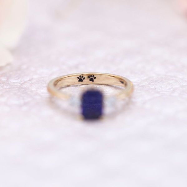 A subtle engraving celebrates the couple’s love of cats in this sapphire engagement ring.