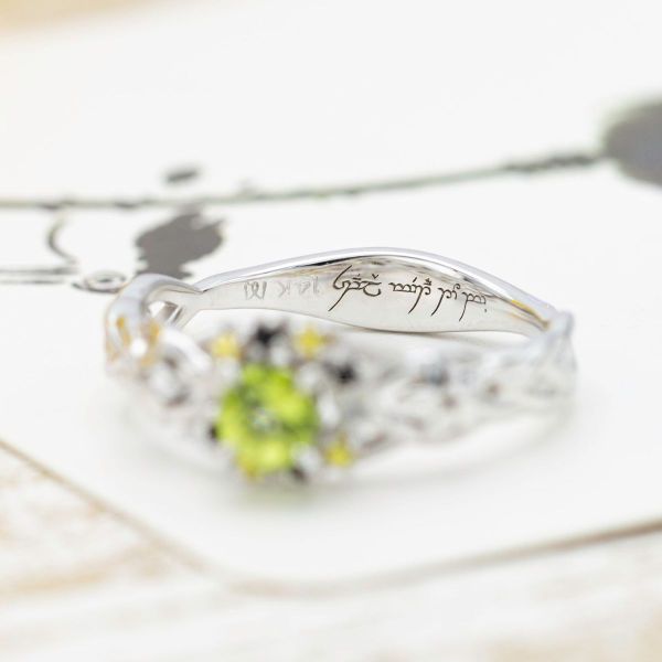 Two fandoms combine in one engagement ring with a peridot center stone and black and yellow accent gems.