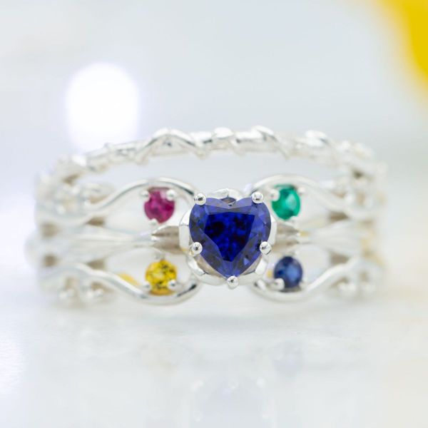 With a heart-shaped sapphire center stone, this engagement ring features a band inspired by Luna Lovegood’s two magic wands.