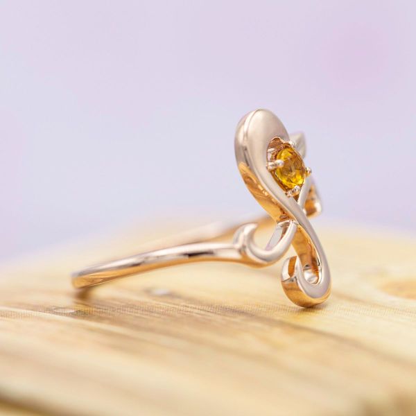A giant pinwheel in rose gold with a sunny citrine resembles Nami’s tattoo in this One Piece inspired engagement ring.