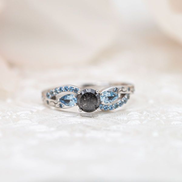 The dark salt and pepper diamond in this ring has a deep opacity.