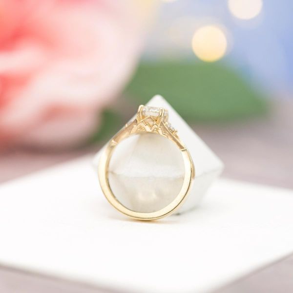 Hidden mountains adorn the side of this yellow gold engagement ring.